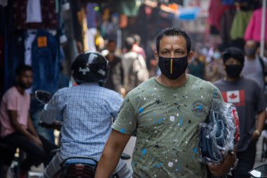 Hint pazarında yüz maskesi takan bir adam, korona salgını nedeniyle maske takmak zorunludur..