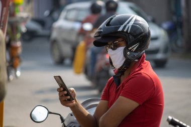 Hindistan 'daki Corona salgını yüzünden yüzünü cep telefonuyla kapatan bir adam.. 