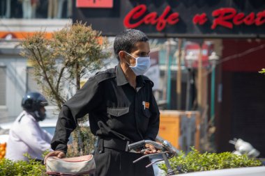 Hindistan 'daki Corona salgınından dolayı maske takan bir güvenlik görevlisi.. 