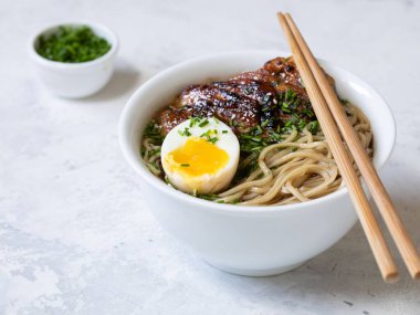 Sarı arka planda Ramen Erişte ve Tavuk Çorbası. Izgara tavuk, erişte ve yumurta yanında yeşil soğan da olsun. Üst Manzara. Kapat..