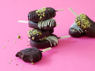 Vejetaryen çikolatalı pasta pembe arka planda dondurma patlatır. Ağzında eriyen lezzetli bir tatlı. Kapat..