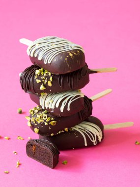 Vejetaryen çikolatalı pasta pembe arka planda dondurma patlatır. Ağzında eriyen lezzetli bir tatlı. Kapat..