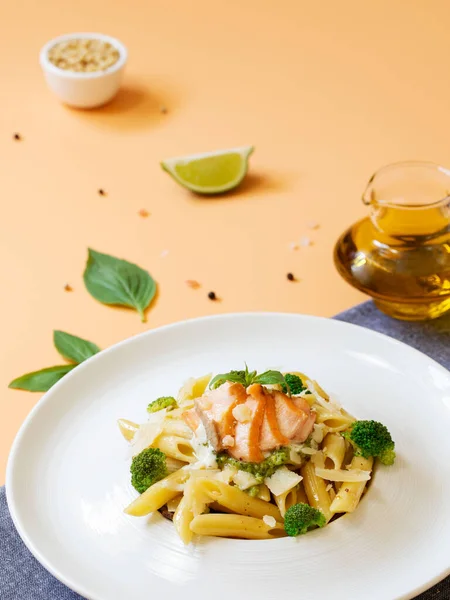 Nudelpenne Mit Lachs Brokkoli Und Pesto Sauce Auf Orangefarbenem Hintergrund — Stockfoto