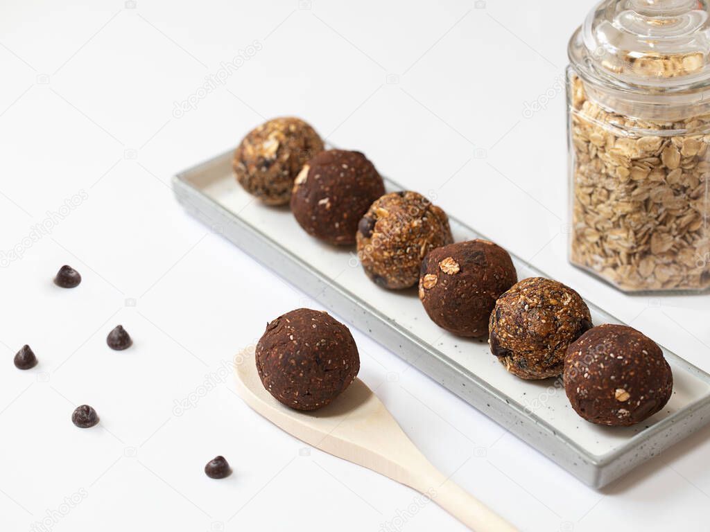 Healthy energy balls with oatmeal, agave syrup, cocoa, and chia seeds on a white background. Selective focus.