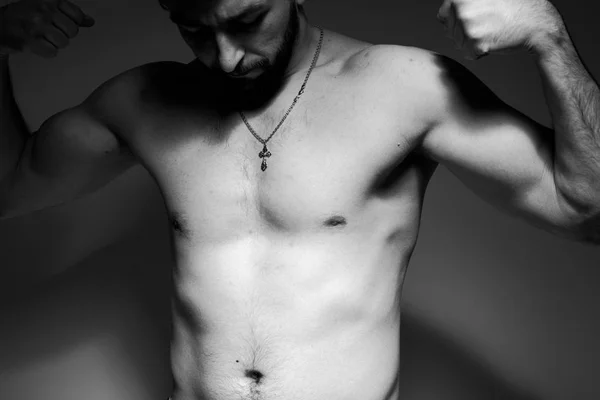 Black and white photo of a handsome and sporty guy close-up in studio