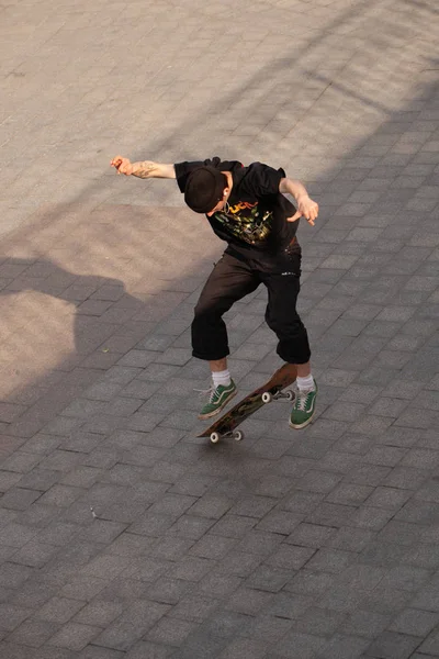 穿着时髦衣服的年轻人在公园里玩滑板 — 图库照片