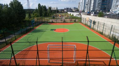 Yüksek evler arasında futbol sahası.