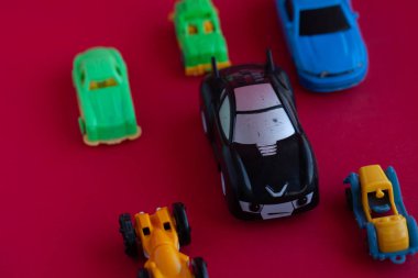 Kırmızı arka planda oyuncak bir arabanın fotoğrafı..