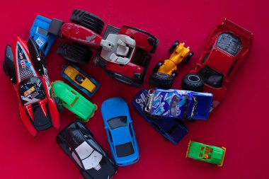 Kırmızı arka planda oyuncak bir arabanın fotoğrafı..