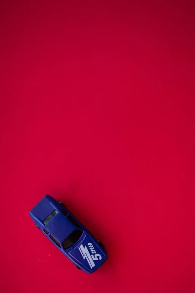 Φωτογραφία Ενός Αυτοκινήτου Παιχνιδιού Κόκκινο Φόντο — Φωτογραφία Αρχείου