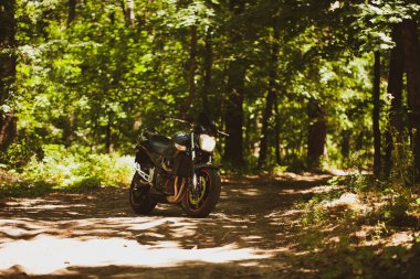 Stüdyodaki gri duvarın arka planında spor siyah motosikleti var..