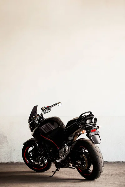 工作室里地下灰墙背景下的黑色运动摩托车 — 图库照片