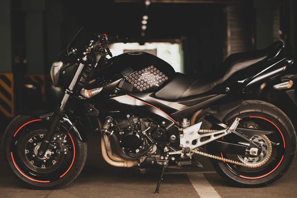 地下駐車場を背景に黒いバイク — ストック写真