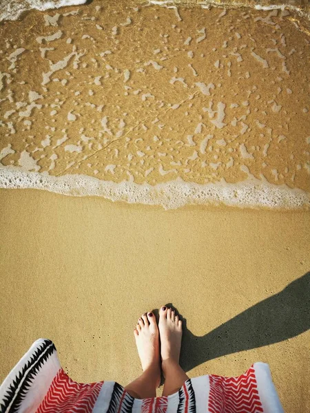 Fille pieds nus debout sur le sable en face des vagues de mer à venir — Photo