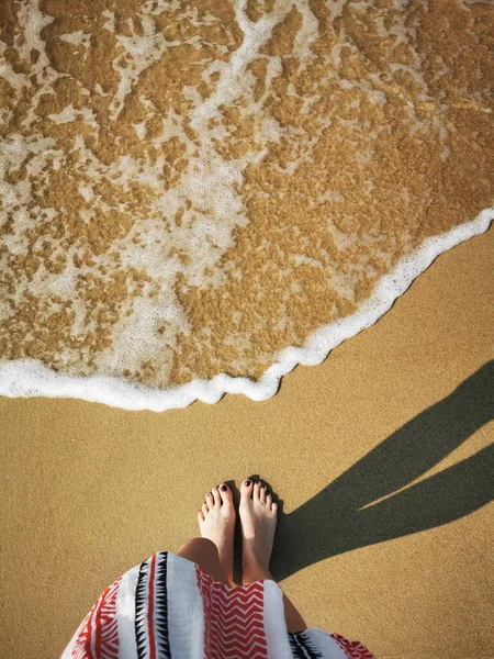 Barefoot meisje staan op het zand in de voorkant van de komende zee golven — Stockfoto