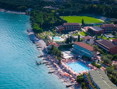 Limonlu konsolos Garda sahilinde yüzen ve güneşlenen insanlar var. Panoramik göl manzarası Garda. Lombardy insansız hava aracı manzarası