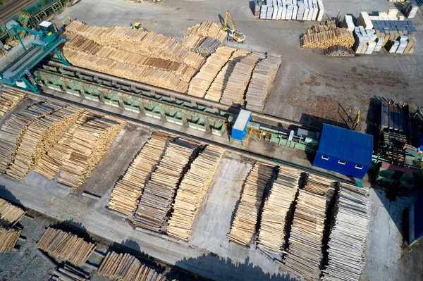 Aserradero vista aérea troncos de madera de árbol picado apilados en una fila con maquinaria — Foto de Stock