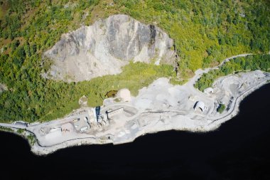 Taş ocağı endüstriyel kazılar yapıyor. Yukarıdan hava manzarası kum tepelerini ve tepeleri gösteriyor.