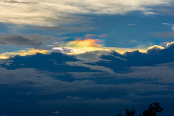 美しい虹色の雲 曇り空のカラフルな雲 虹色の雲 虹色の山 前景の木のシルエット — ストック写真