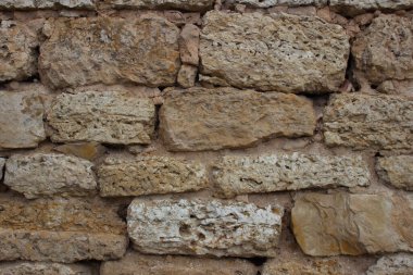 Kumtaşından eski taş duvar.