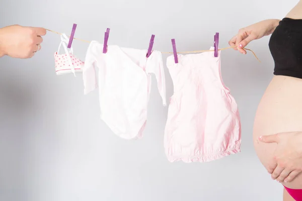 Vader Zwangerschap Moeder Houdt Een Waslijn Met Toekomstige Babykleding Omdat — Stockfoto