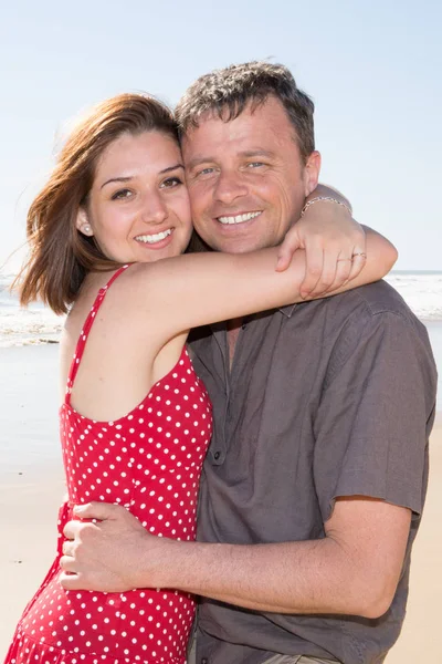 幸せな若いカップルがハグして 笑いのビーチ — ストック写真