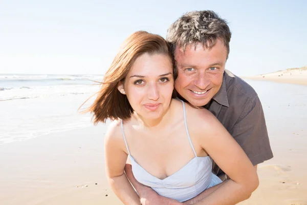 背景に海のある夏にビーチで愛情深く寄り添うカップル — ストック写真