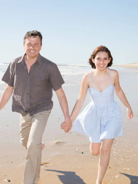 smile happy couple walking on sea beach in summer