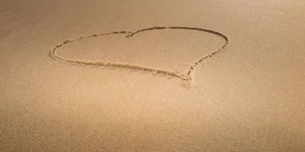 図面を愛の心のシンボルとして海の背景で黄色の砂の上 — ストック写真