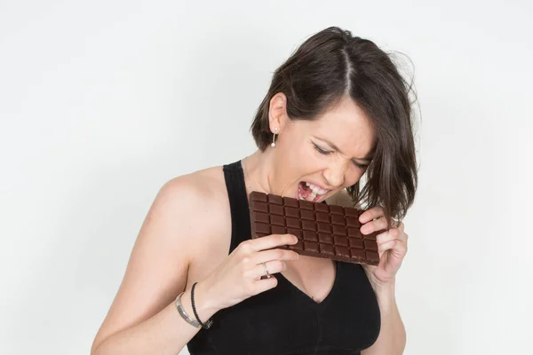 灰色の背景に分離されたチョコレートを食べると楽しい女の子試飲甘いチョコレート — ストック写真