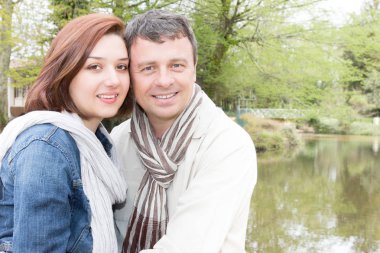 Nehir Gölü yakınındaki bir parkta bir bankta oturan erkek ve kadın gezginler