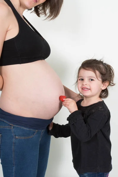 Girl Plays Her Mother Pregnant Belly Strawberry — Stock Photo, Image