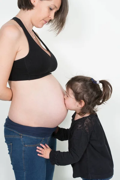 现代家庭单身母亲等待新生儿而女儿亲吻怀孕的腹部 — 图库照片