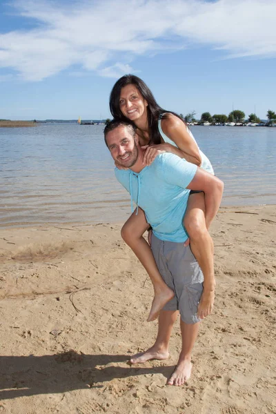 Uomo Che Trasporta Una Ragazza Sulla Schiena Spiaggia All Aperto — Foto Stock