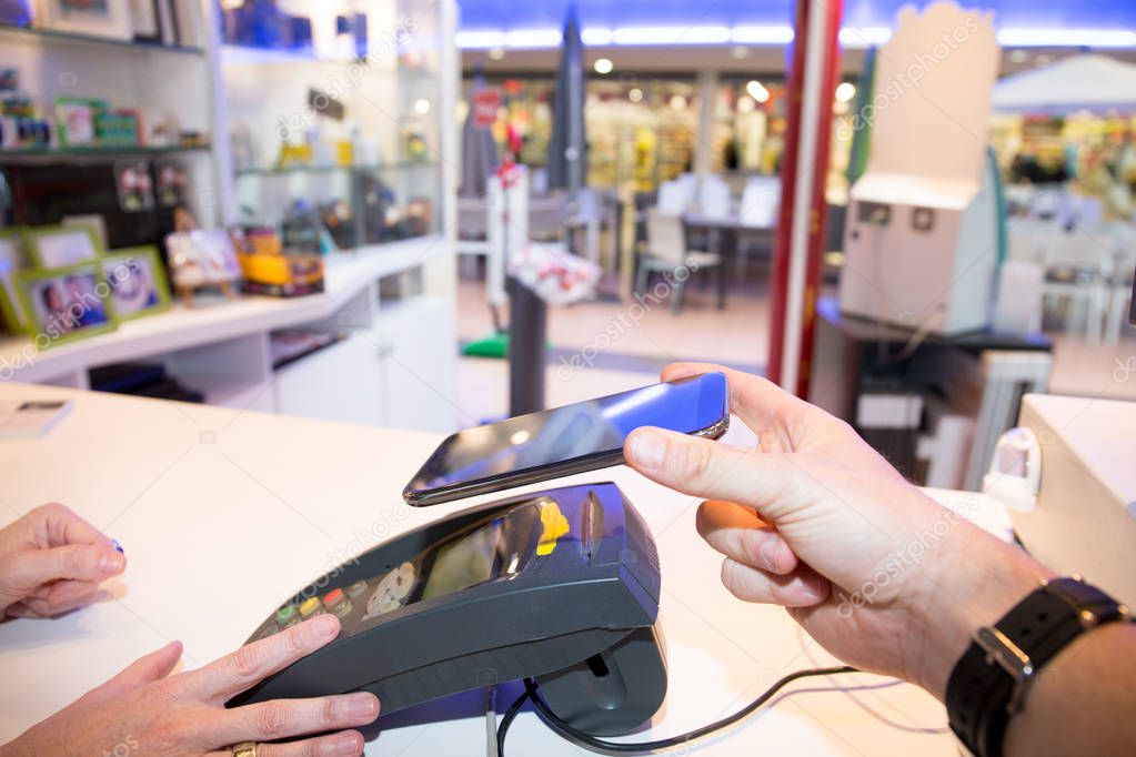 Man paying bill through smartphone using NFC technology mobile payment