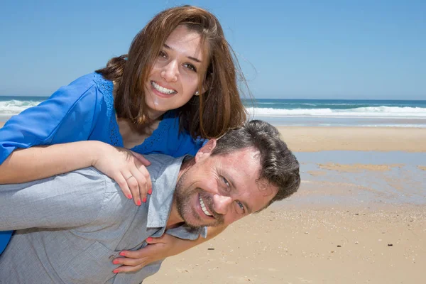 白人男子夫妇小猪背在海滩上拥抱 — 图库照片