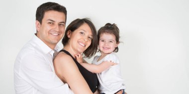 mutlu aile anne baba çocuk kız evde beyaz duvar içinde gülümseyen