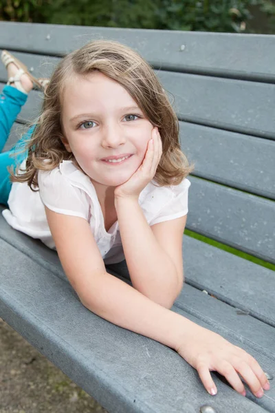 Glada Barn Barn Flicka Liggande Utomhus Bänk Park — Stockfoto