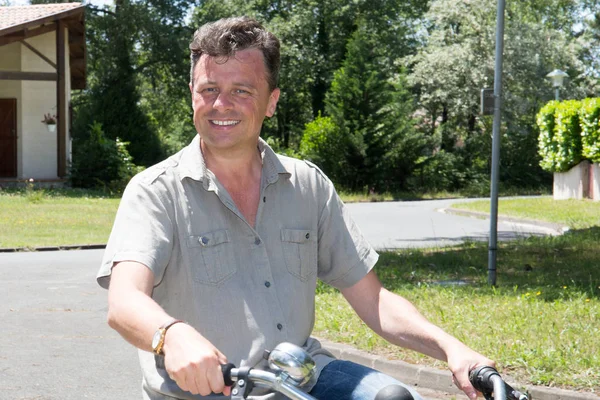 handsome middle aged man with bike make bicycle in city street