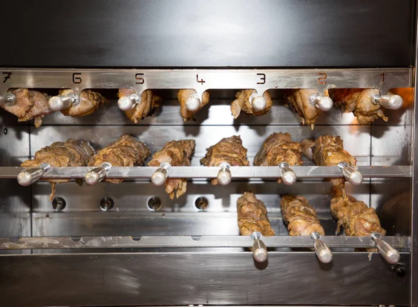 an industrial oven with pieces of meat in the rotisserie baking