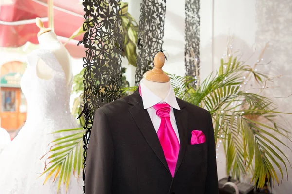 elegant male mannequin presenting luxury suits tuxedo groom and male fashion accesories in wedding dress shop