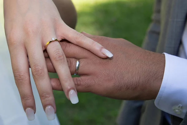 Young married couple holding hands in outdoors ceremony wedding day
