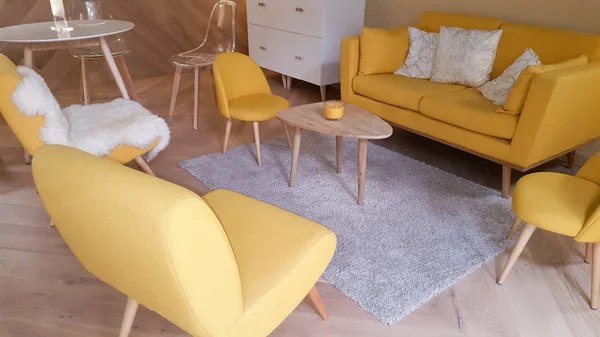 Modern retro yellow living room with sofa and armchair