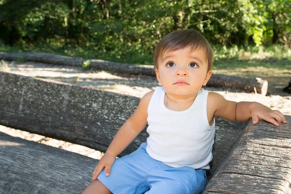 Feliz Niño Sonriente Posando Banco Madera Verde Parque Natural Fondo — Foto de Stock