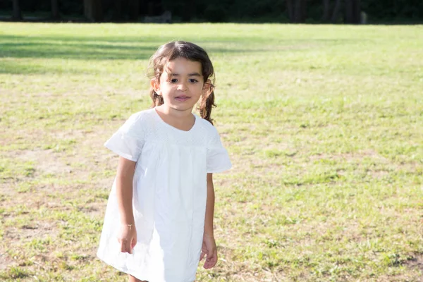 Σγουρά Παιδί Μελαχρινή Κοπέλα Λευκό Φόρεμα Καλοκαιρινό Πράσινο Λιβάδι — Φωτογραφία Αρχείου