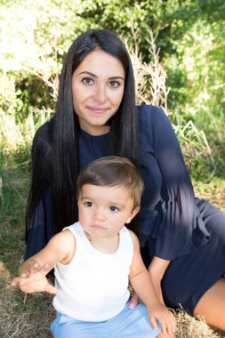 güzel güzellik anne kadın oturup yakışıklı çocuk oğluyla çimlerin üzerine yaz