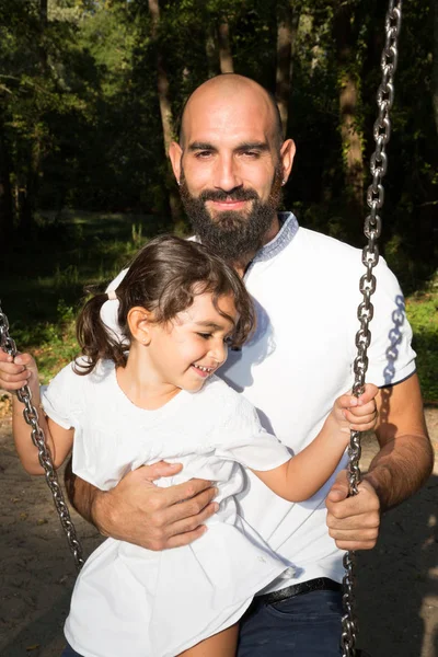 Bärtiger Vater Hilft Seiner Tochter Auf Der Spielplatzschaukel — Stockfoto
