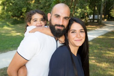 güzel mutlu aile baba ve anne ile kızı çocuk rahat kıyafetler içinde sıcak yaz gününde yürüyüş