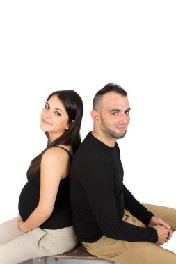 Bir çocuk için bekleyen gülümseyen çift birbirlerine sırt sırta beyaz arka plan üzerinde eğilir
