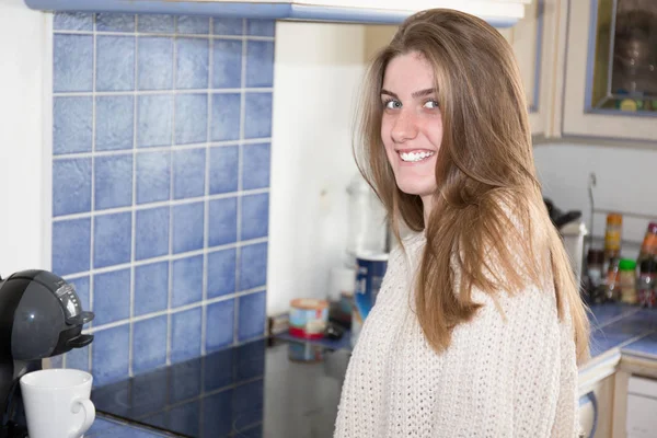家の台所で若い笑顔の金髪女性 — ストック写真